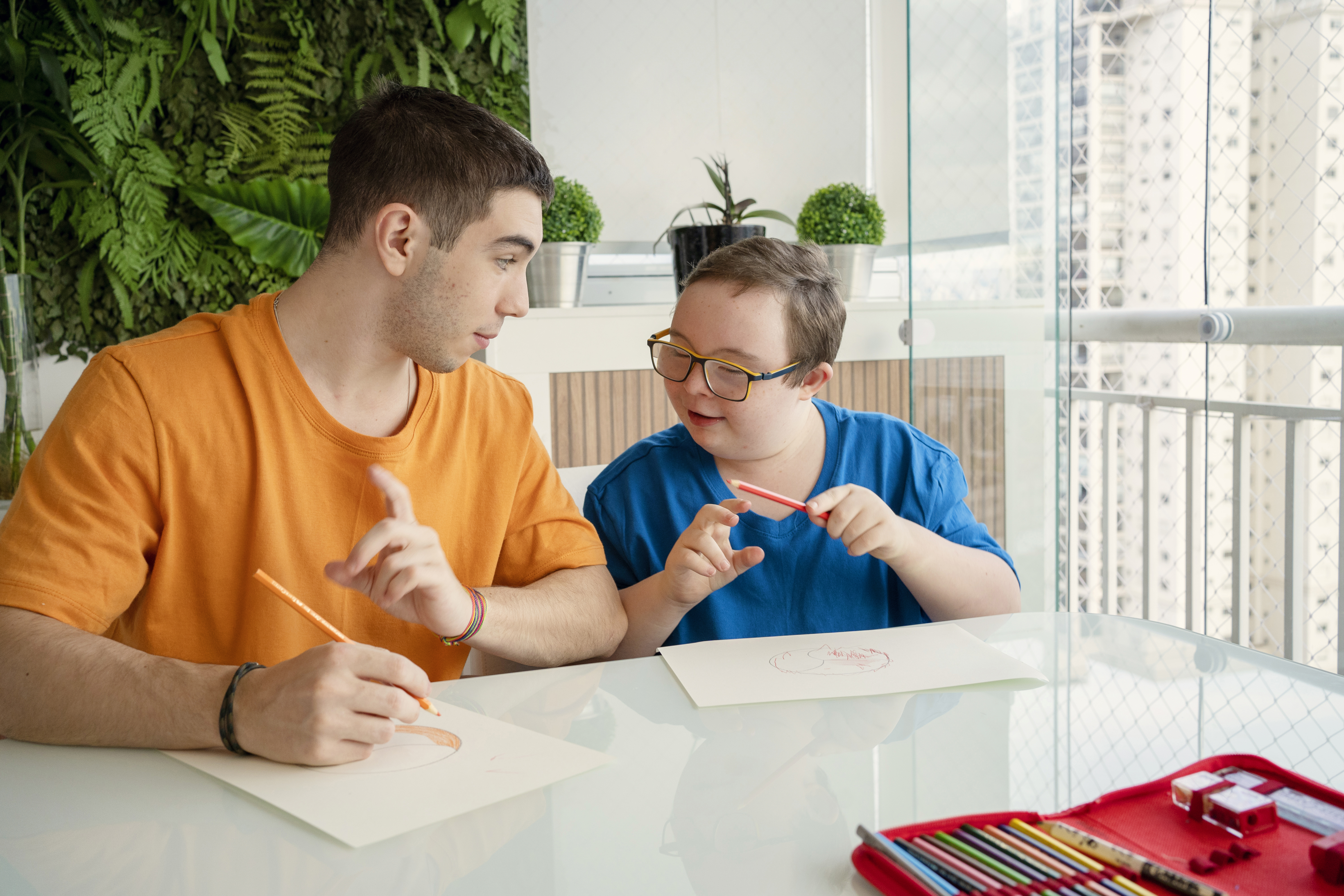 Boy with down syndrome and his brother drawing